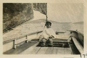Image of Boy steering old fishing boat